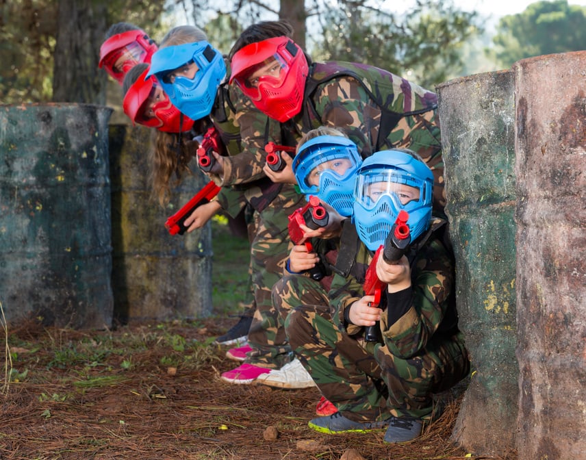 Group of friendly kids playing paintball